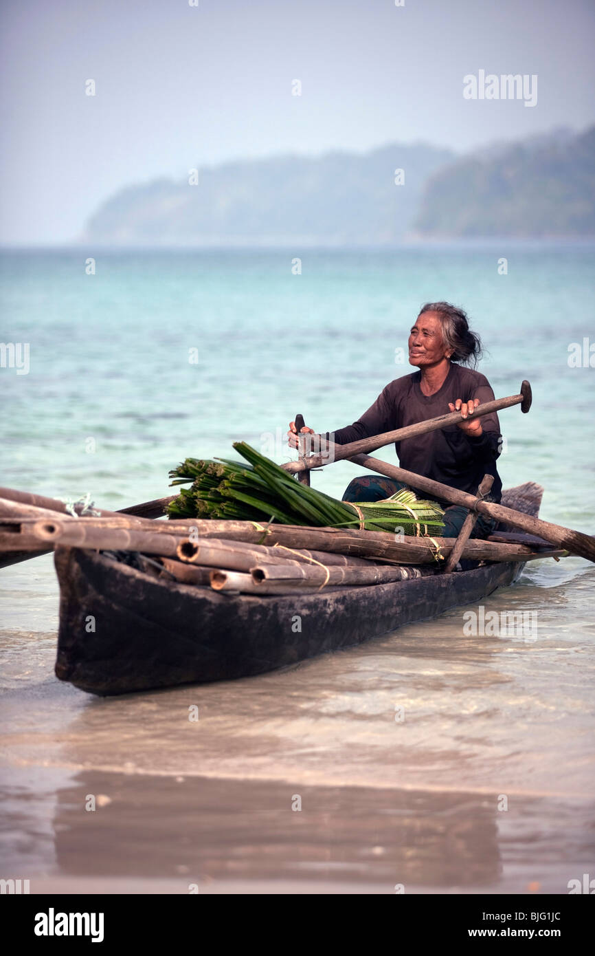 An old lady, one of the Myanmar sea-gypsies, the nomadic hunter-gatherers of South East Asia, transporting her wares by canoe Stock Photo