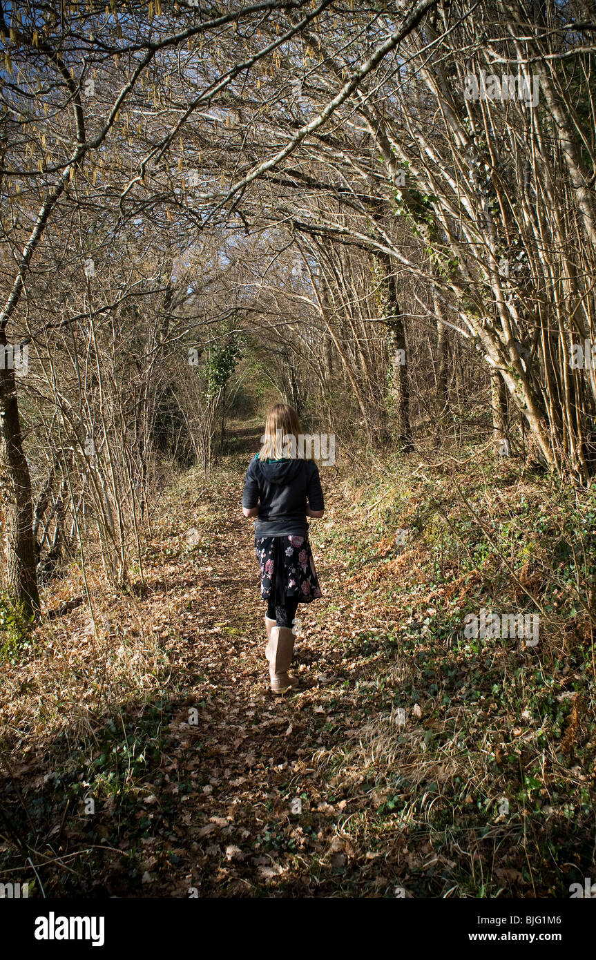 Young girl walking through woods,autumn, relaxed, casual, open, youth, forest, winter, fall, tree, girls, studying, literature,hike jaunt parade, step Stock Photo