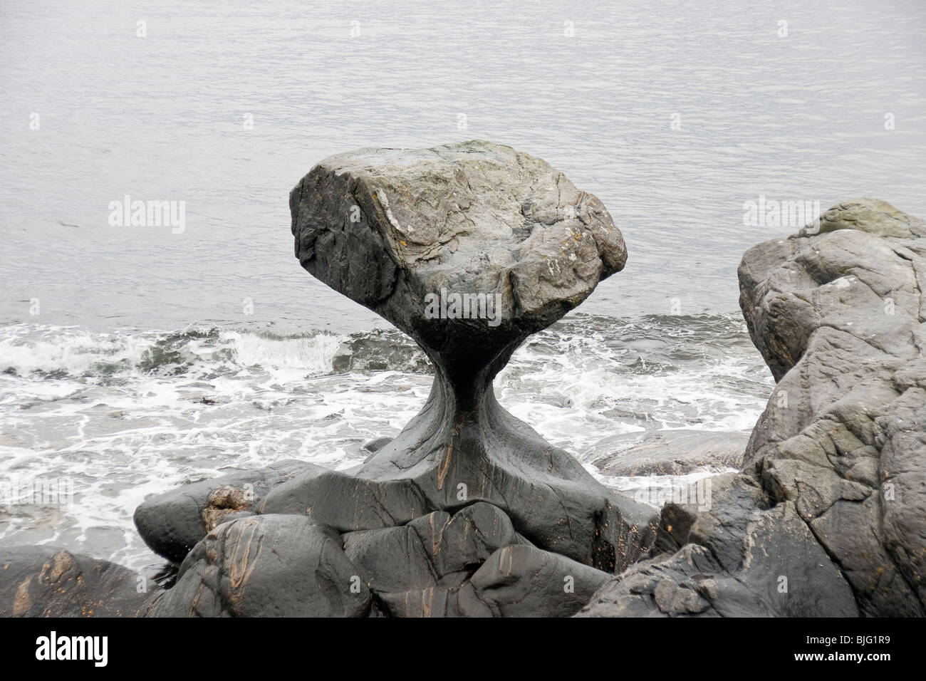 Unusual stone in Atlantic ocean coast. View on Kannesteinen and Kvalheimsvika. Stock Photo
