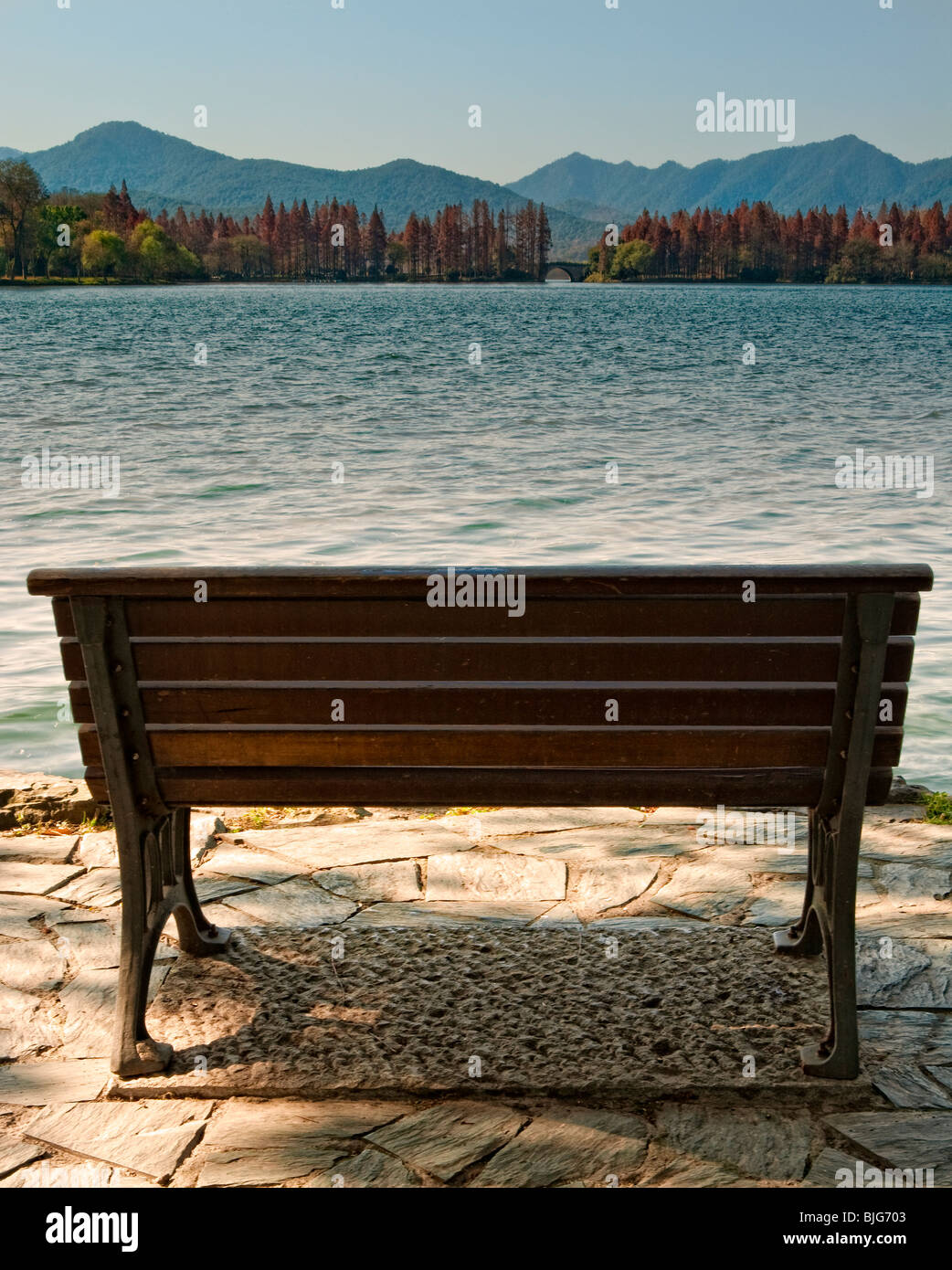 An empty lone chair/bench facing the west lake, Hangzhou, Zhejiang, China Stock Photo