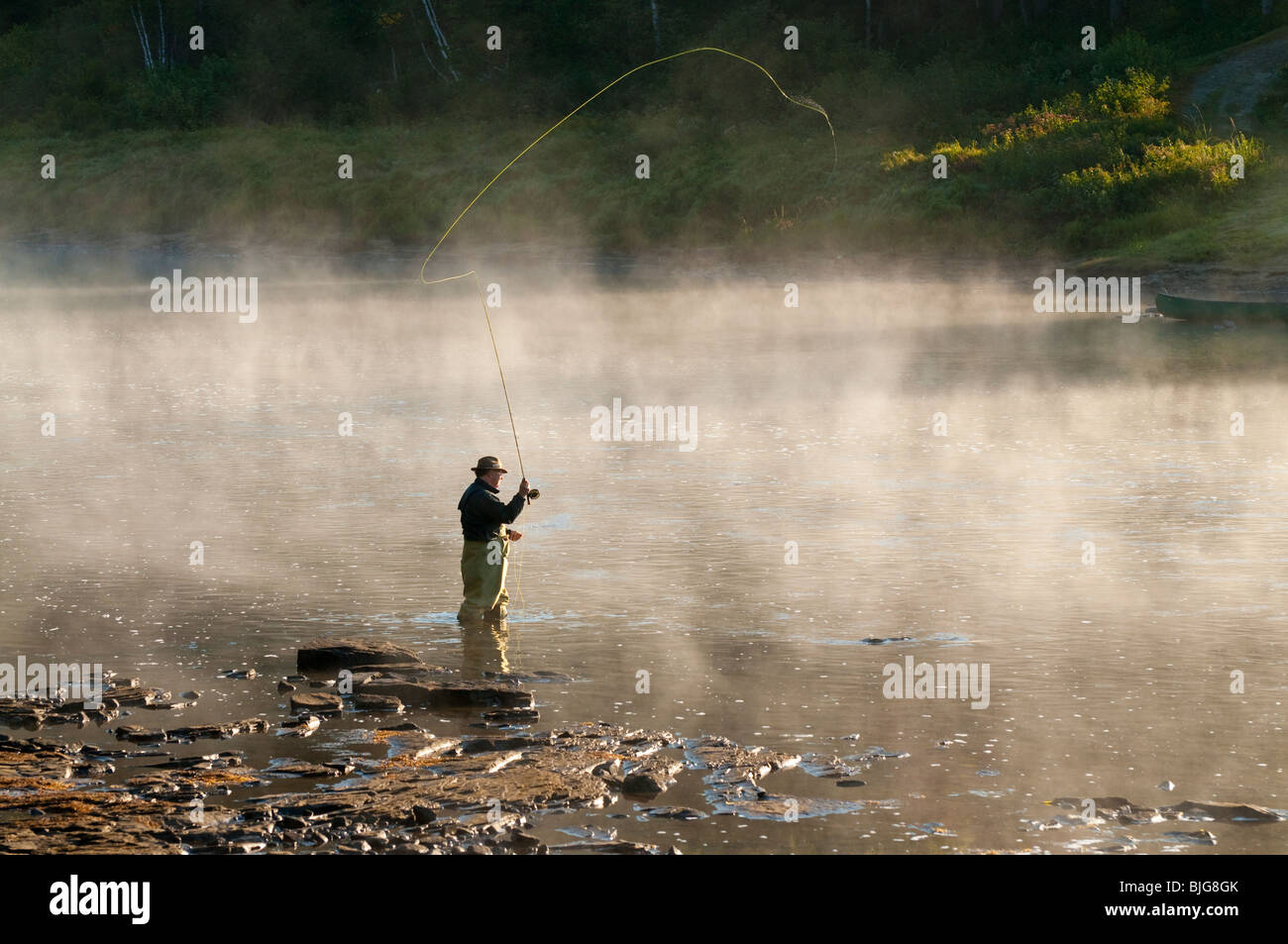 NEW BRUNSWICK, Fly Fisherman casting for Atlantic Salmon in early