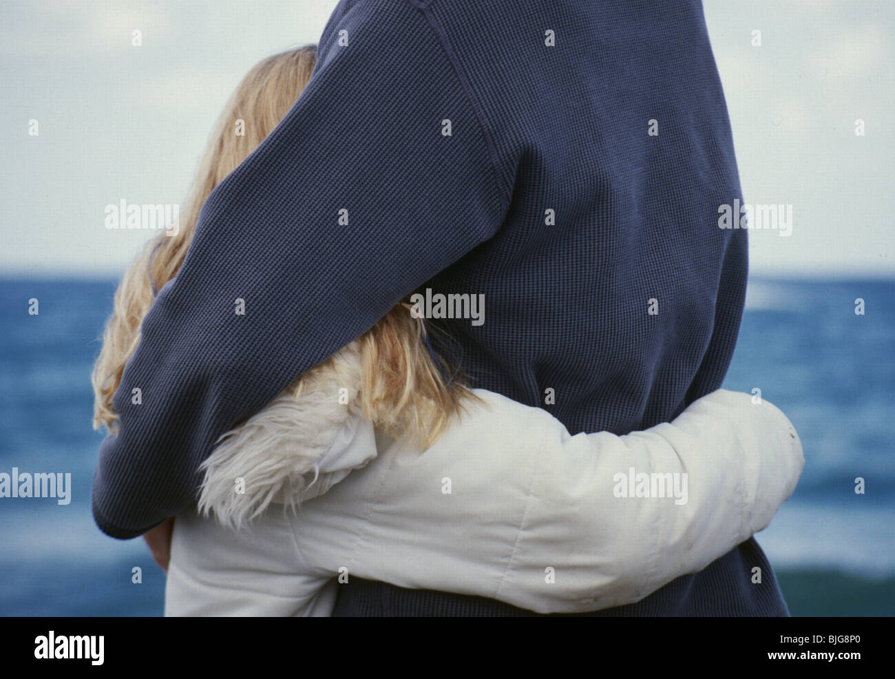 Shared Child Custody contact rights: Dad holding or cherish teenage girl at waterfront; back view anonymous, vulnerable child  SerieCVS100029054 Stock Photo