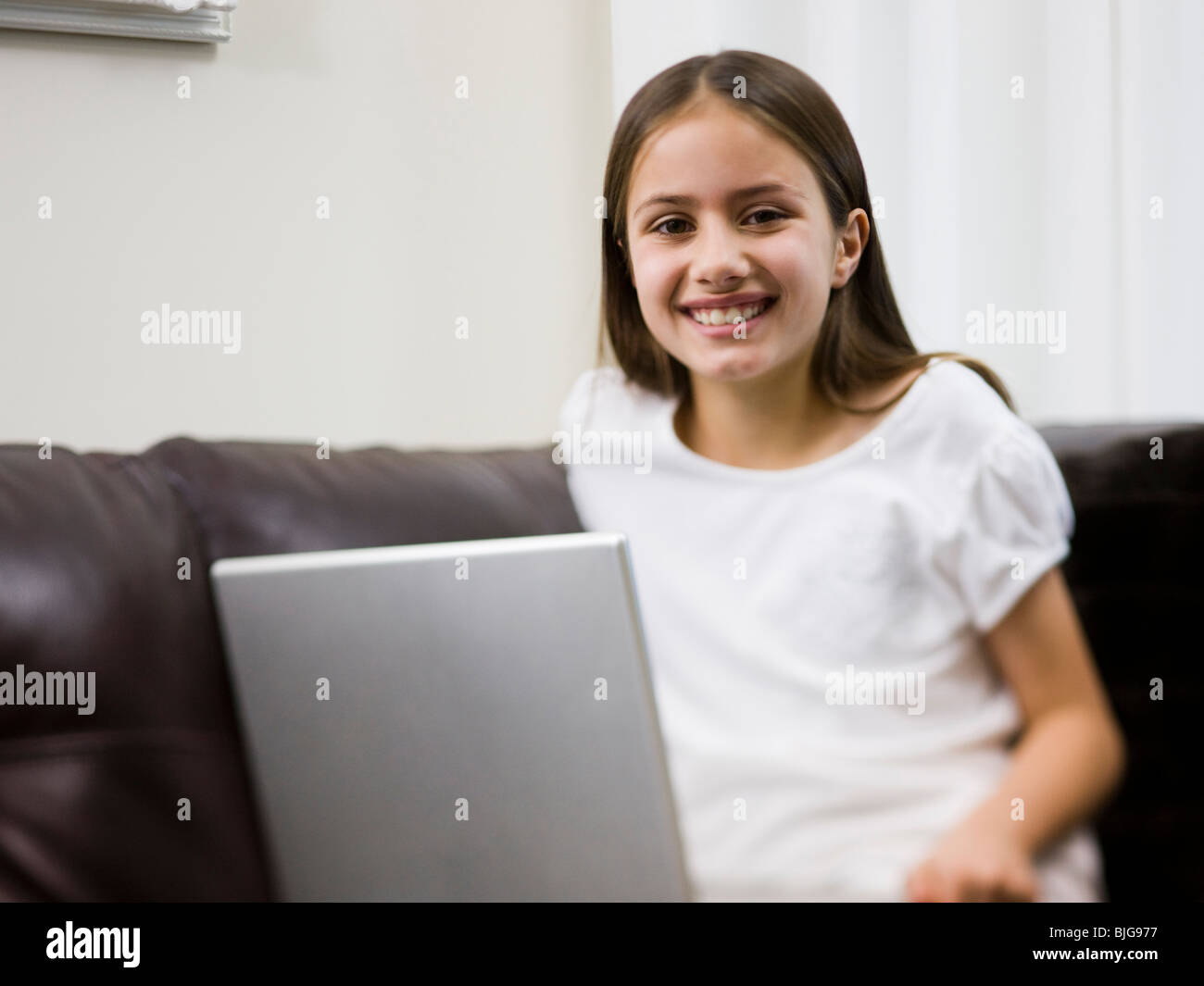 girl on a sofa with a laptop Stock Photo