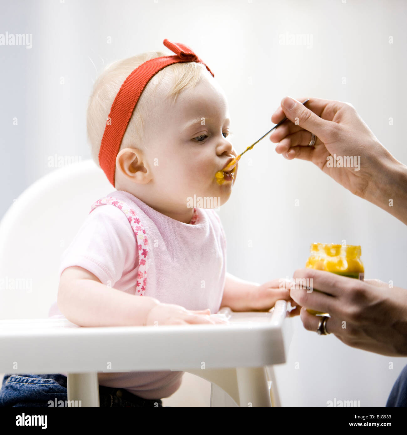 baby girl in a high chair Stock Photo Alamy