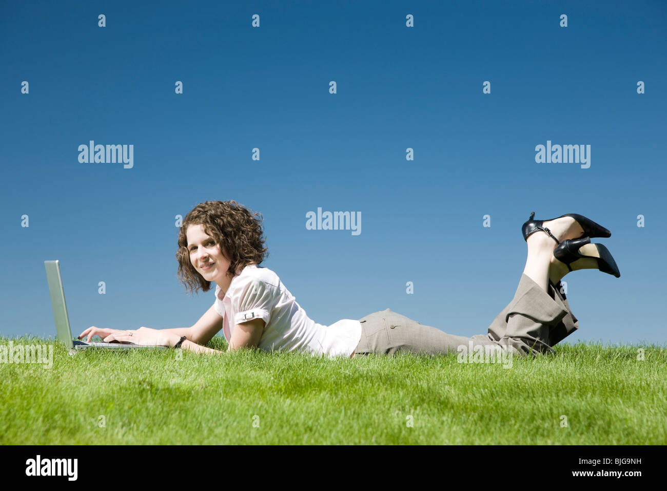 woman lying on the grass using a laptop Stock Photo - Alamy