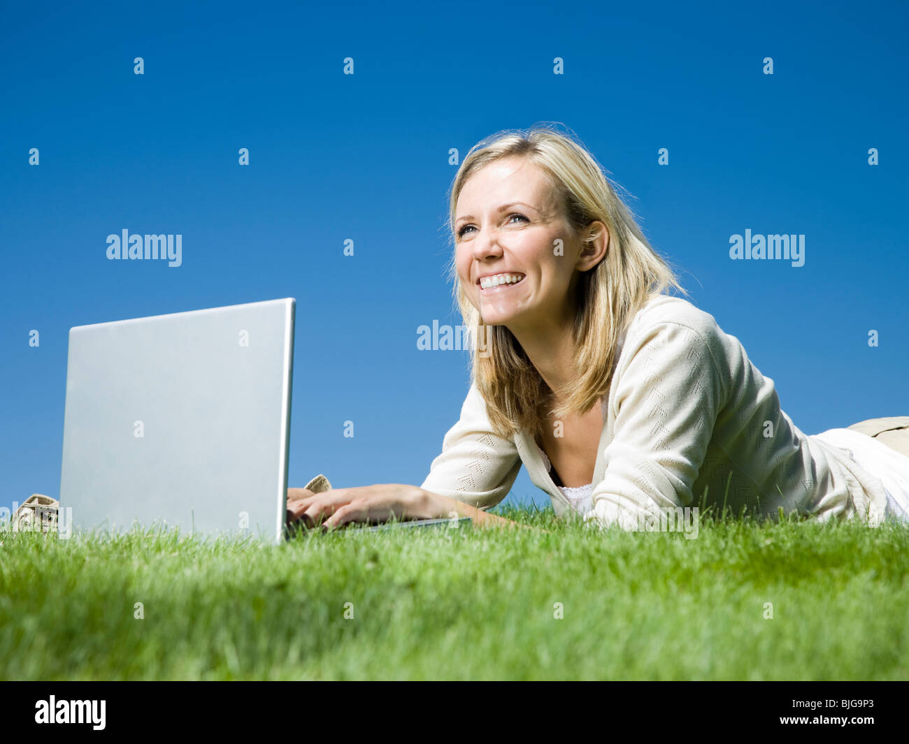 woman lying on the grass using a laptop Stock Photo - Alamy