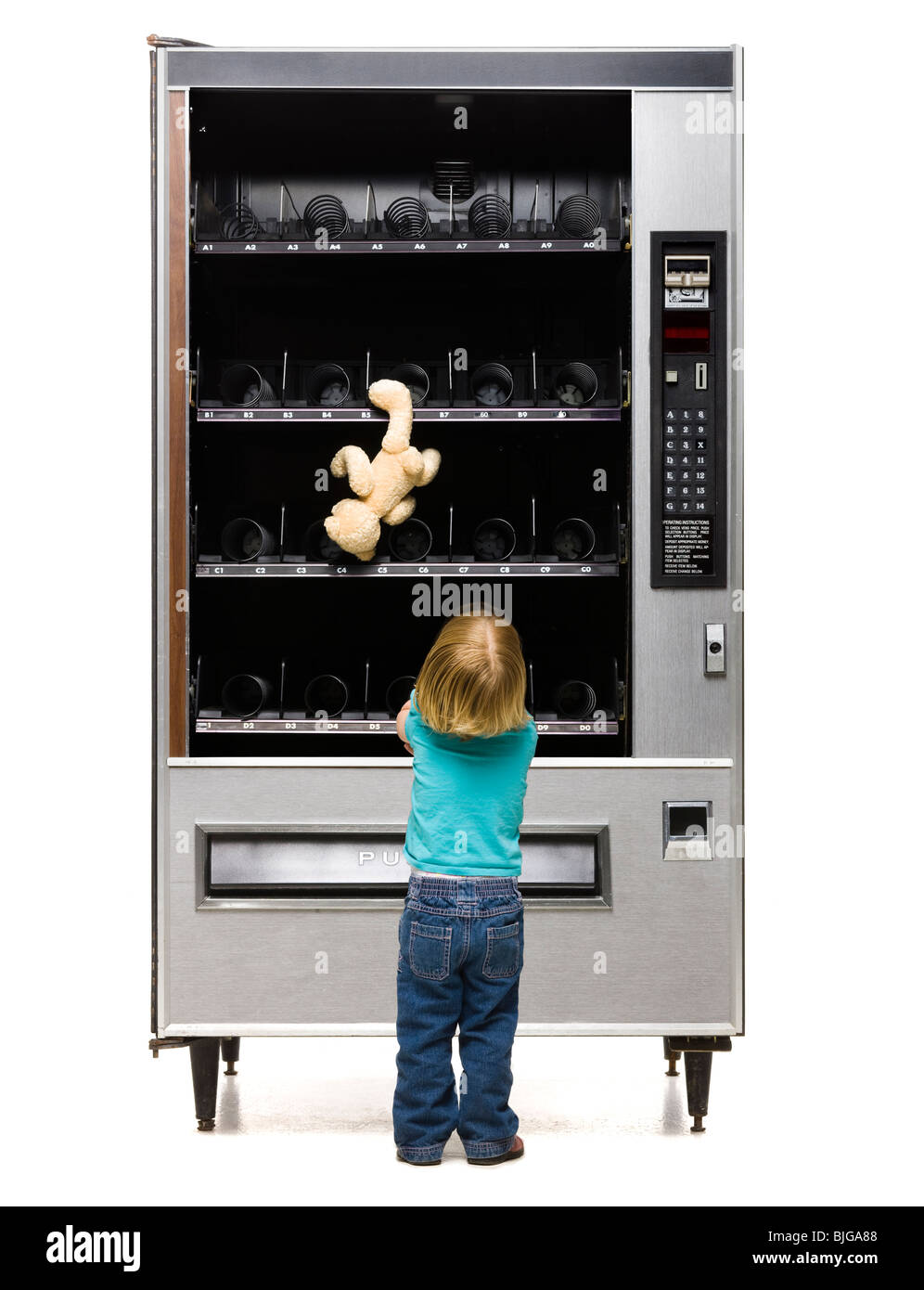 girl buying a teddy bear from a vending machine Stock Photo