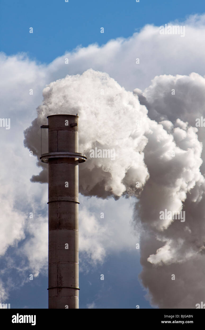 A smokestack billows smoke and steam in rural Nebraska. Shot from public highway. Stock Photo