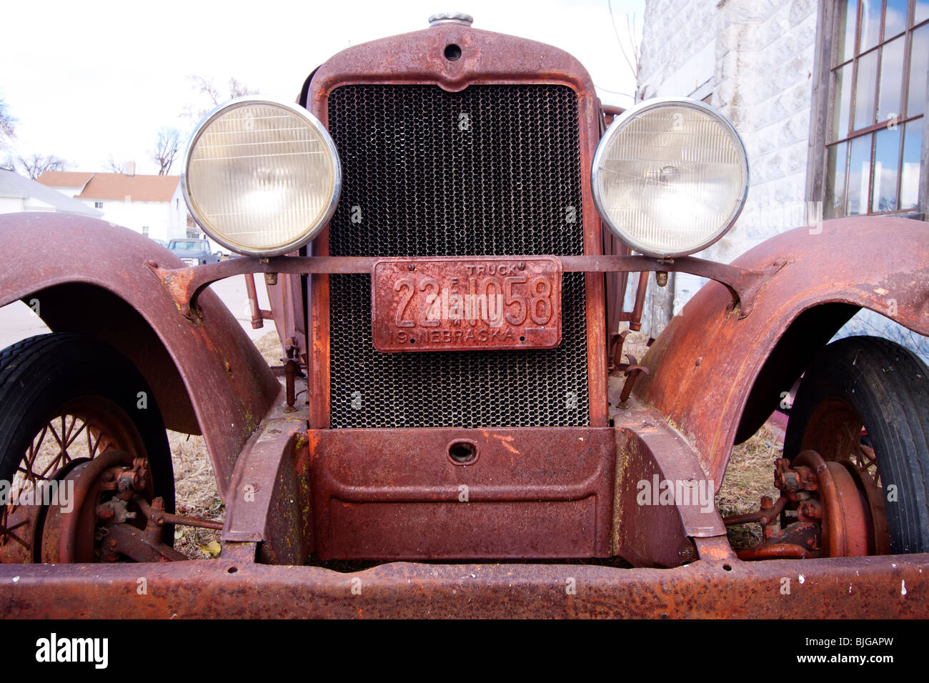A rusted farm license plate on a rusting out antique car in Nebraska USA. Stock Photo