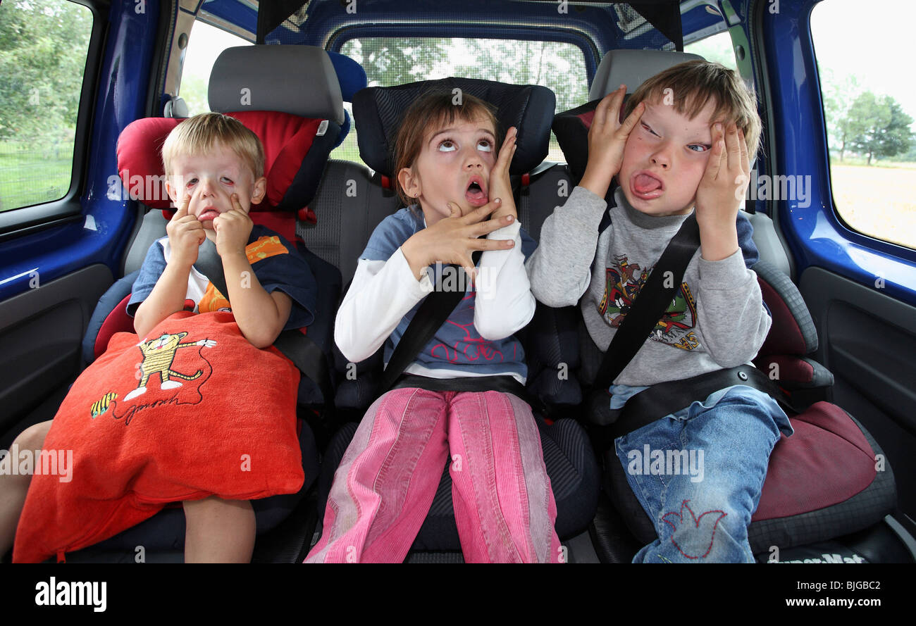 Children in a car making silly faces Stock Photo