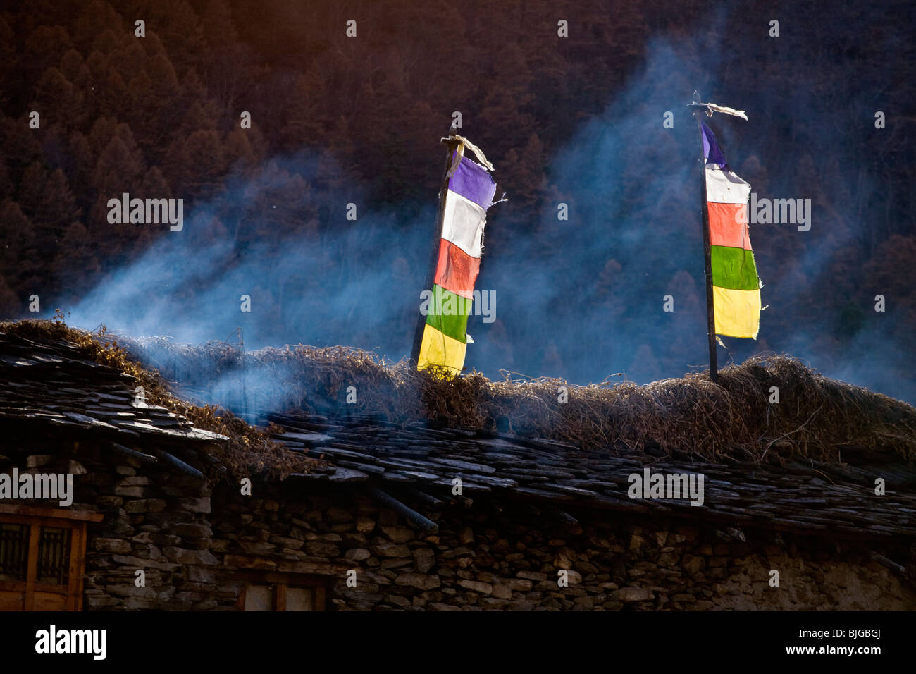 TIBETAN PRAYER FLAGS on a roof in the village of SAMAGAUN on the AROUND MANASLU TREK - NUPRI REGION, NEPAL Stock Photo