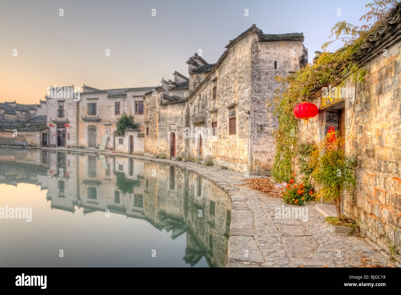 Stone Houses next to a pound in a Chinese village at sunrise, Ahui, China Stock Photo
