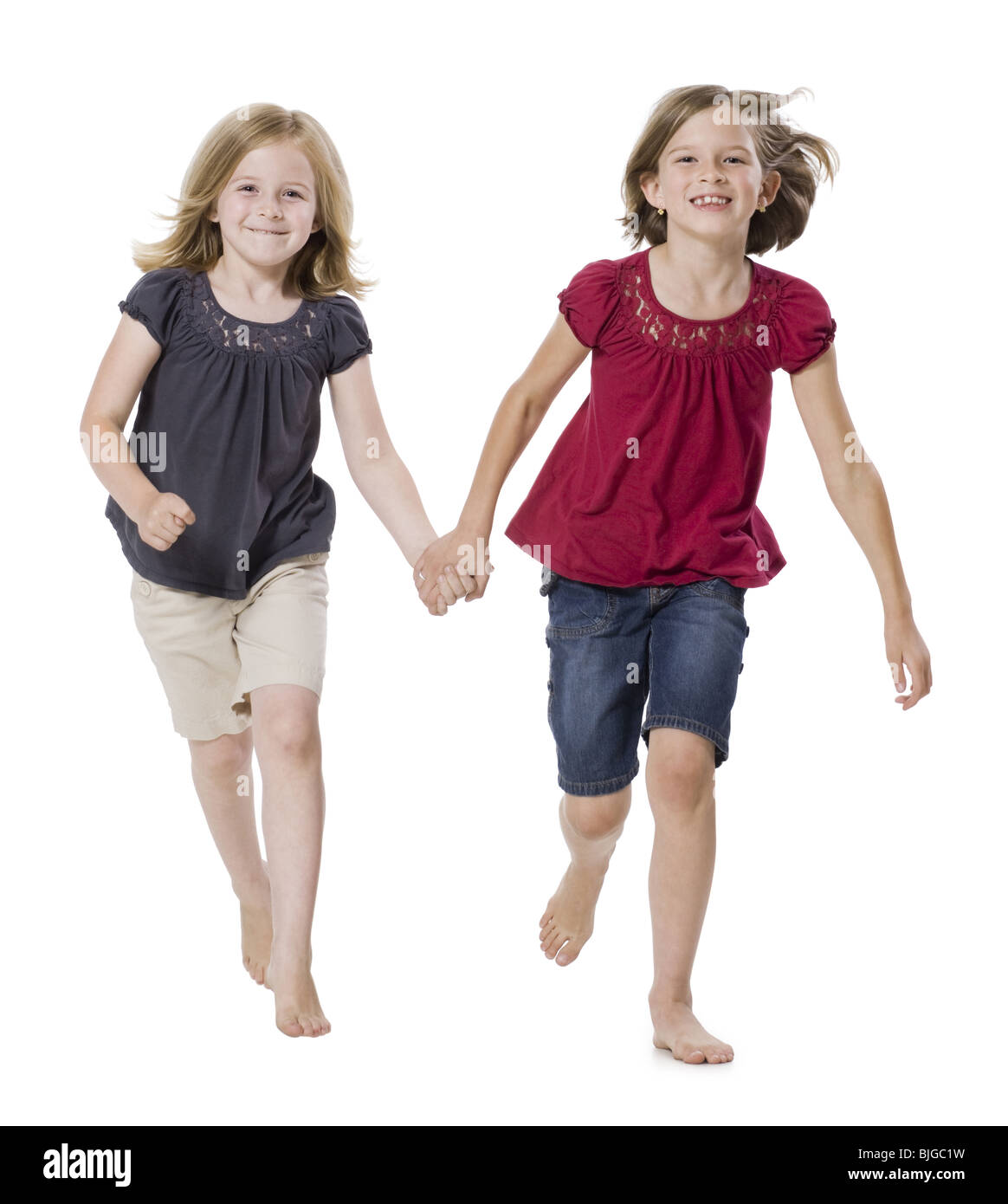 Two girls running holding hands Cut Out Stock Images & Pictures - Alamy