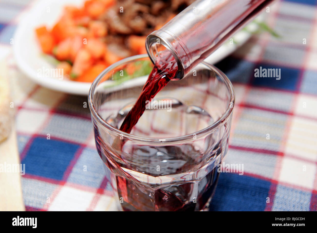 Home made italian cuisine, pouring red wine in a glass Stock Photo