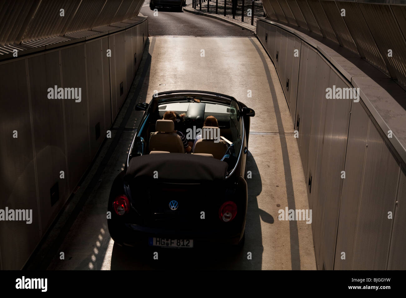Convertible car Volkswagen Beetle driving out of underground parking garage rear elevated view exiting exit automobile VW Stock Photo