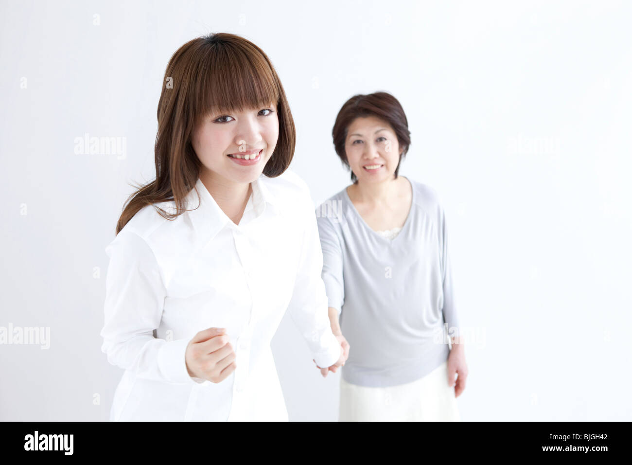 Mother and daughter holding hands Stock Photo - Alamy
