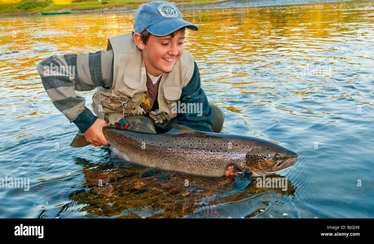 NEW BRUNSWICK Teenage fisherman releasing Atlantic Salmon on the Famous Miramichi River Stock Photo