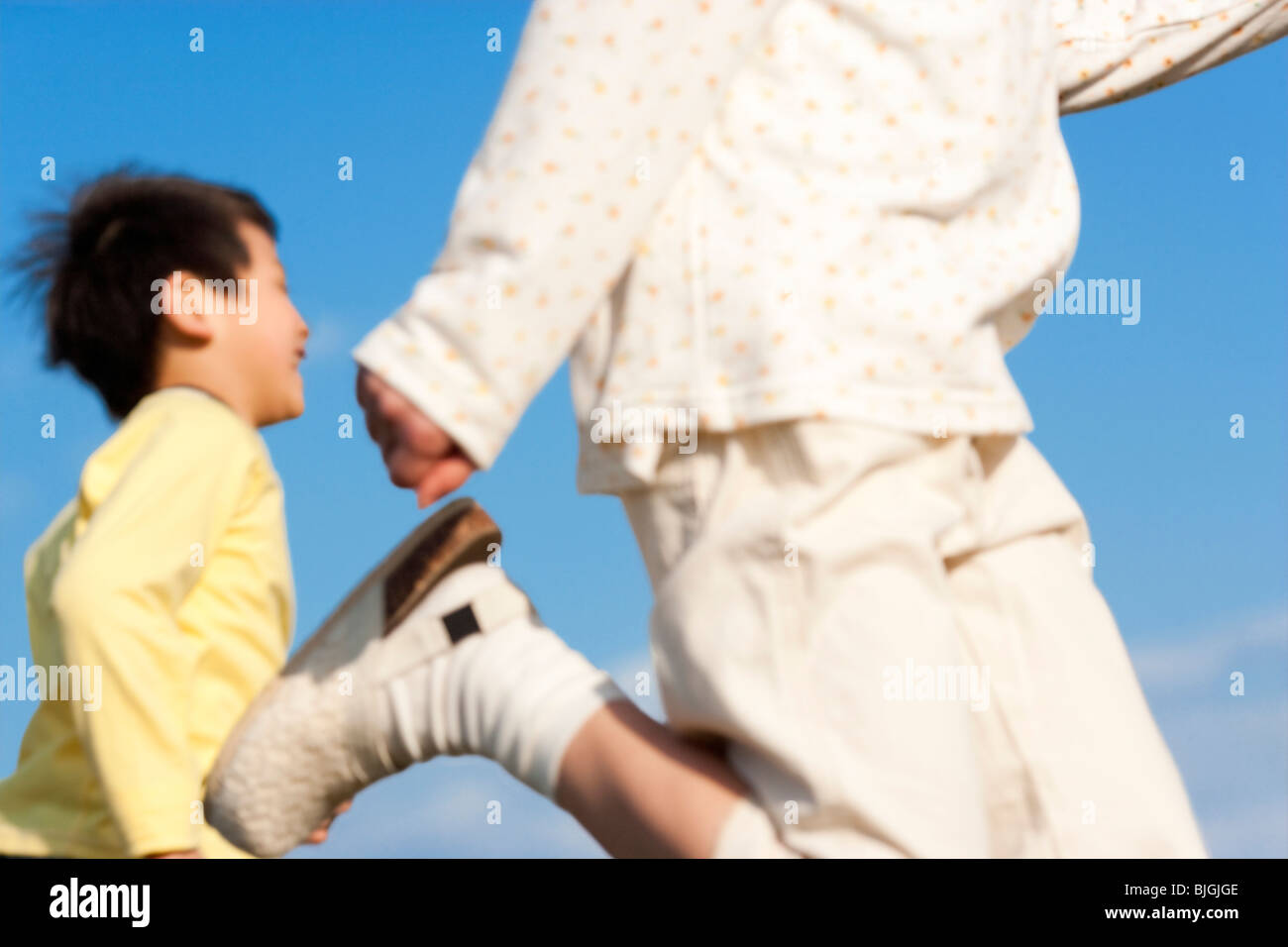 Brother and sister running against a blue sky Stock Photo - Alamy