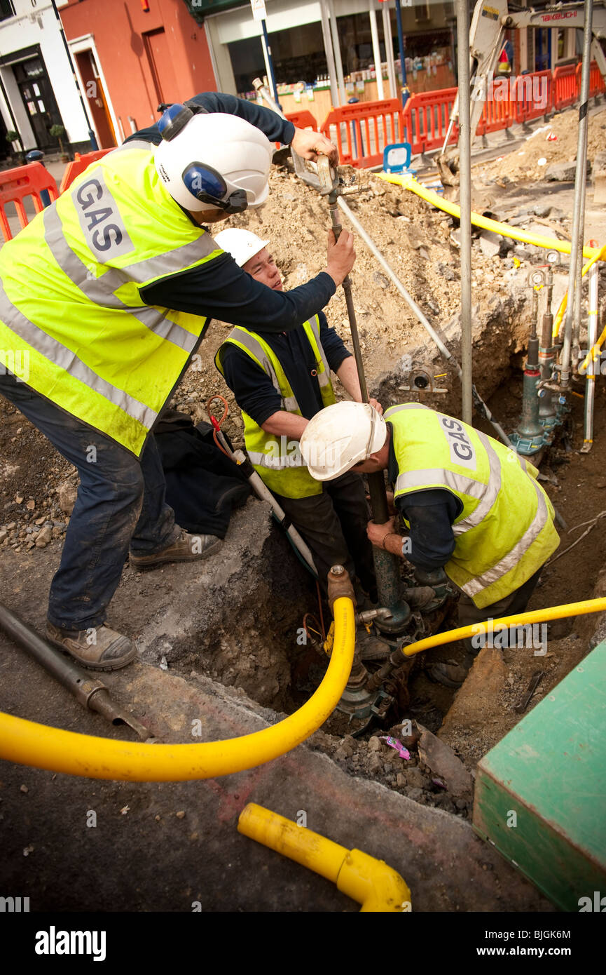 British Gas engineers replacing a steel gas supply main with a yellow plastic pipe alternative, UK Stock Photo