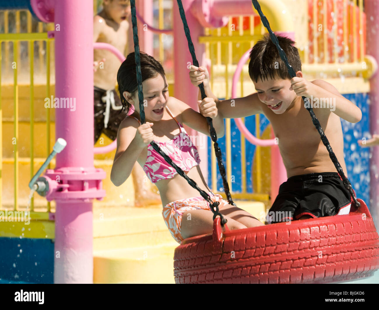 children on a tire swing at a waterpark Stock Photo