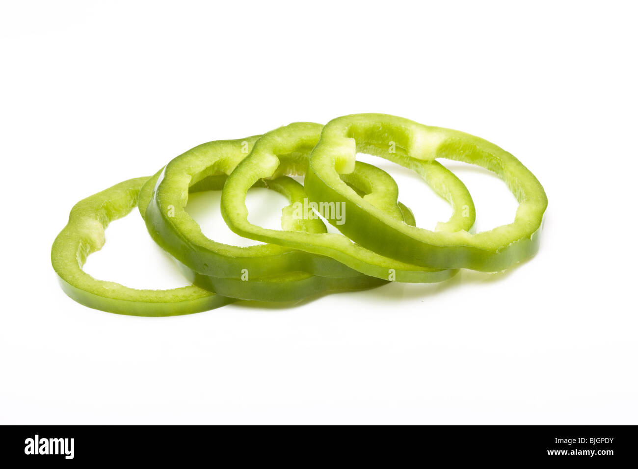 Sliced Green Peppers arranged on white background. Stock Photo