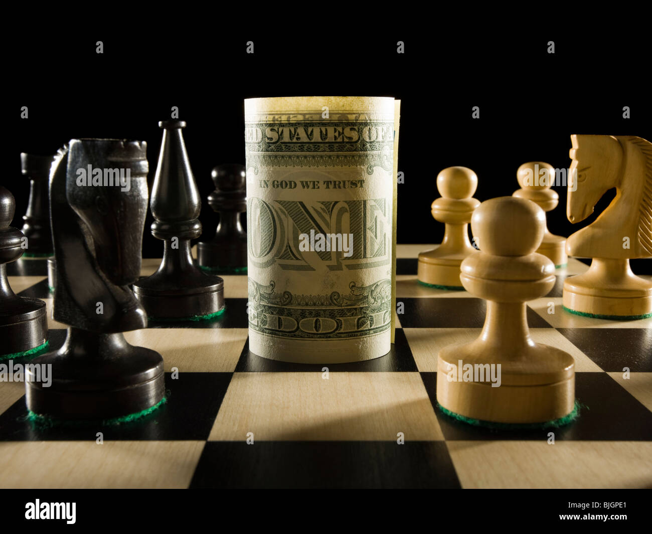 rolled currency on a chess board Stock Photo
