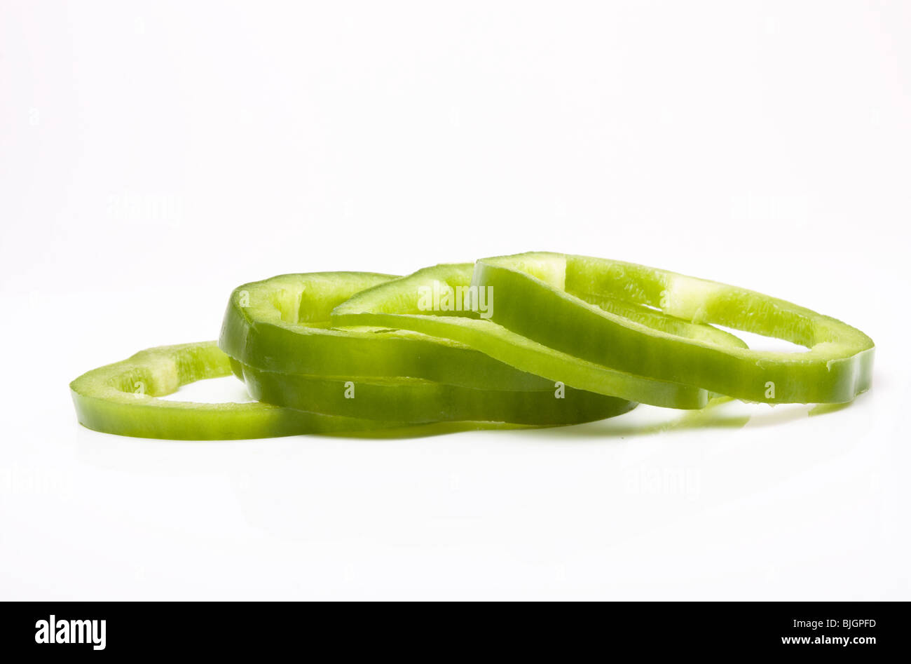 Sliced Green Peppers arranged on white background. Stock Photo