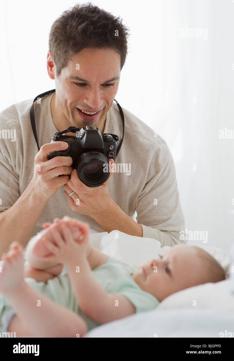 Father taking photograph of baby Stock Photo