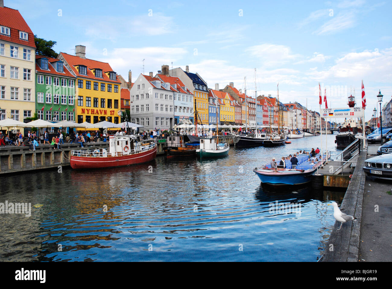 Sighteeing boat on the canal in Nyhavn, a colourful 17th century waterfront and entertainment district in Copenhagen, Denmark. Stock Photo