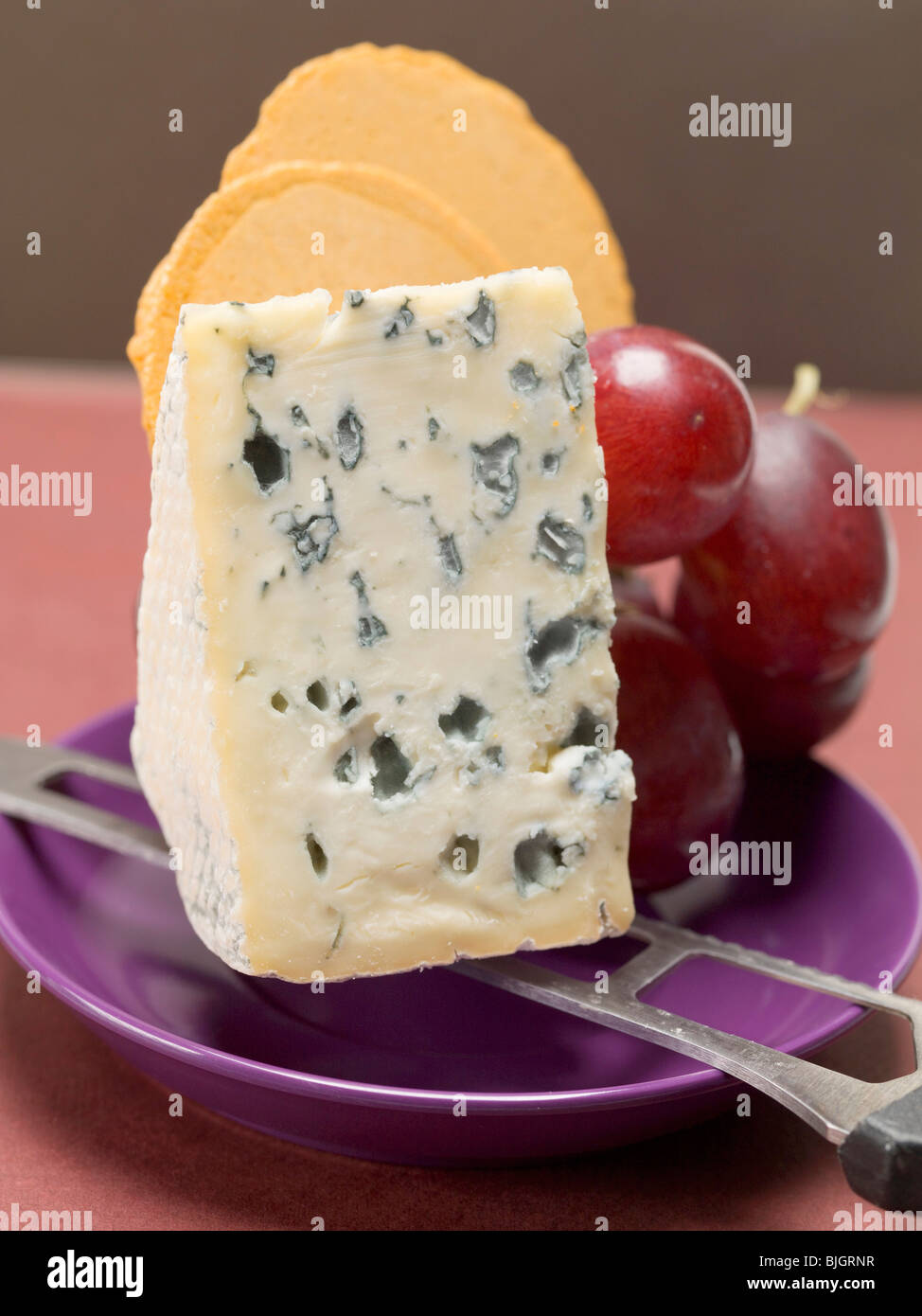 Piece of blue cheese, red grapes and crackers - Stock Photo