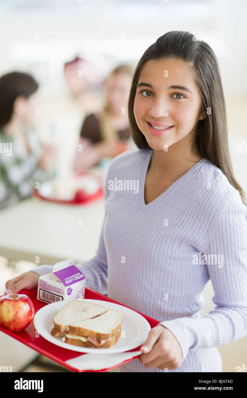 Girl holding tray of cafeteria food Stock Photo