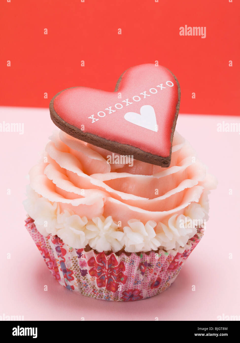 Cup cake with marzipan rose and pastry heart - Stock Photo