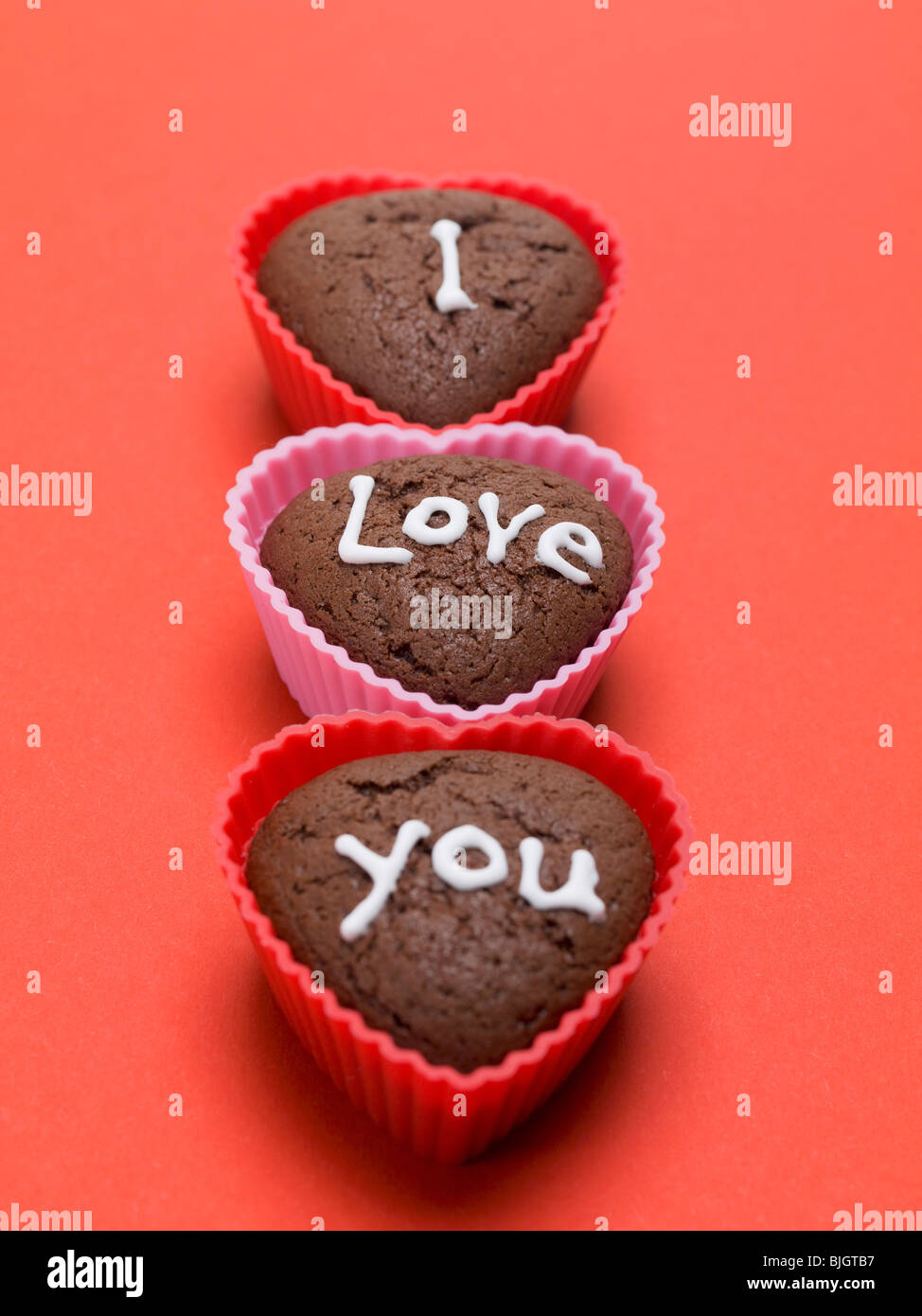 Heartshaped chocolate muffins with white sugar writing Stock Photo Alamy