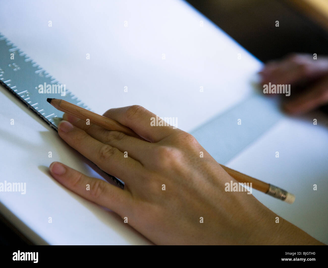 hand using a square on a drafting table Stock Photo Alamy