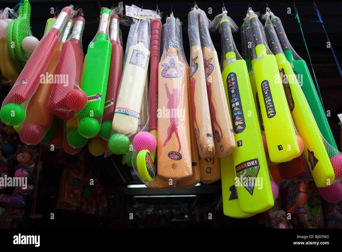 India, Kerala, Calicut, Kozhikode, SM Street, colourful plastic cricket bats hanging outside toy shop Stock Photo