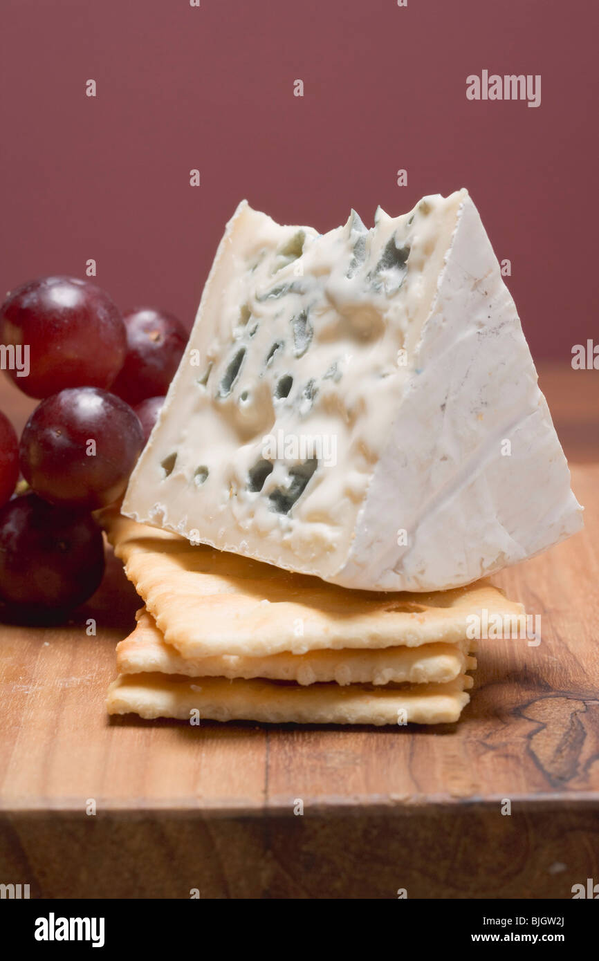 Piece of blue cheese with crackers and red grapes - Stock Photo