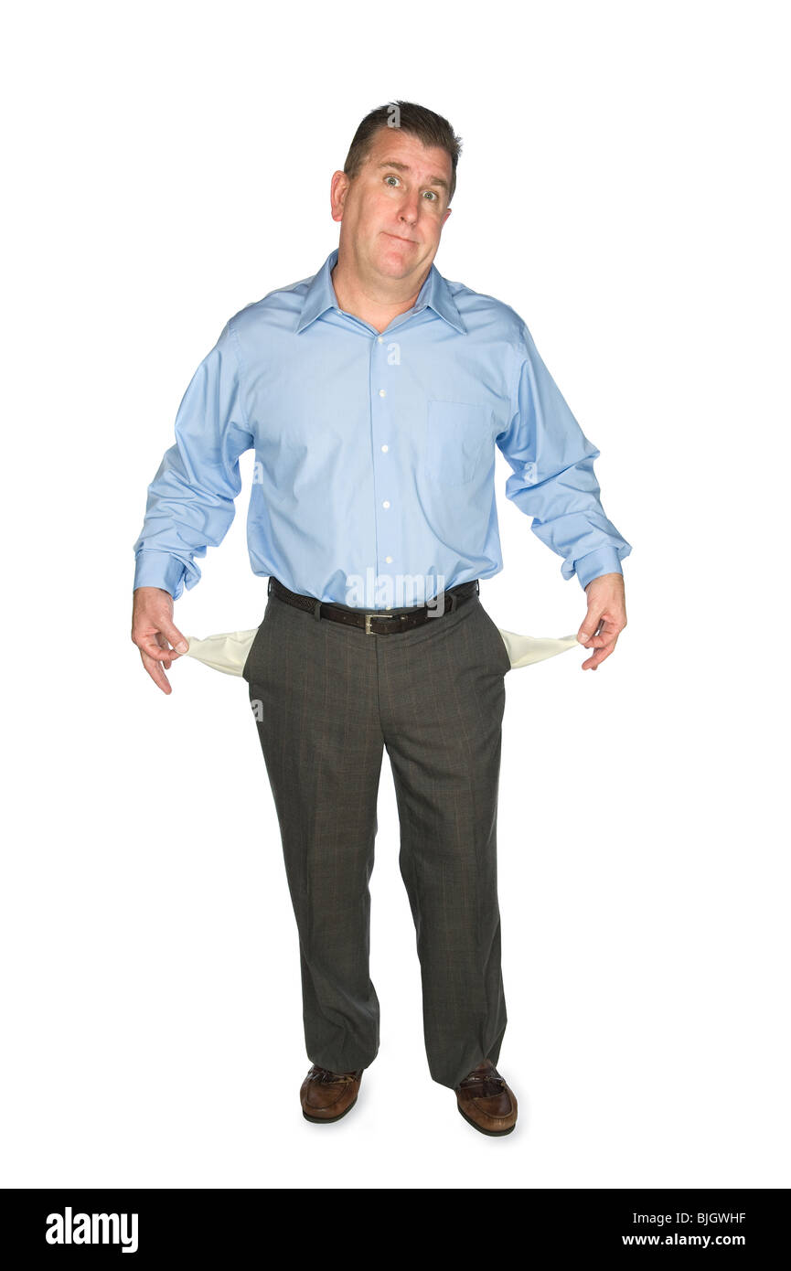 A businessman holds out his empty pockets showing that he is broke and has no cash. Stock Photo