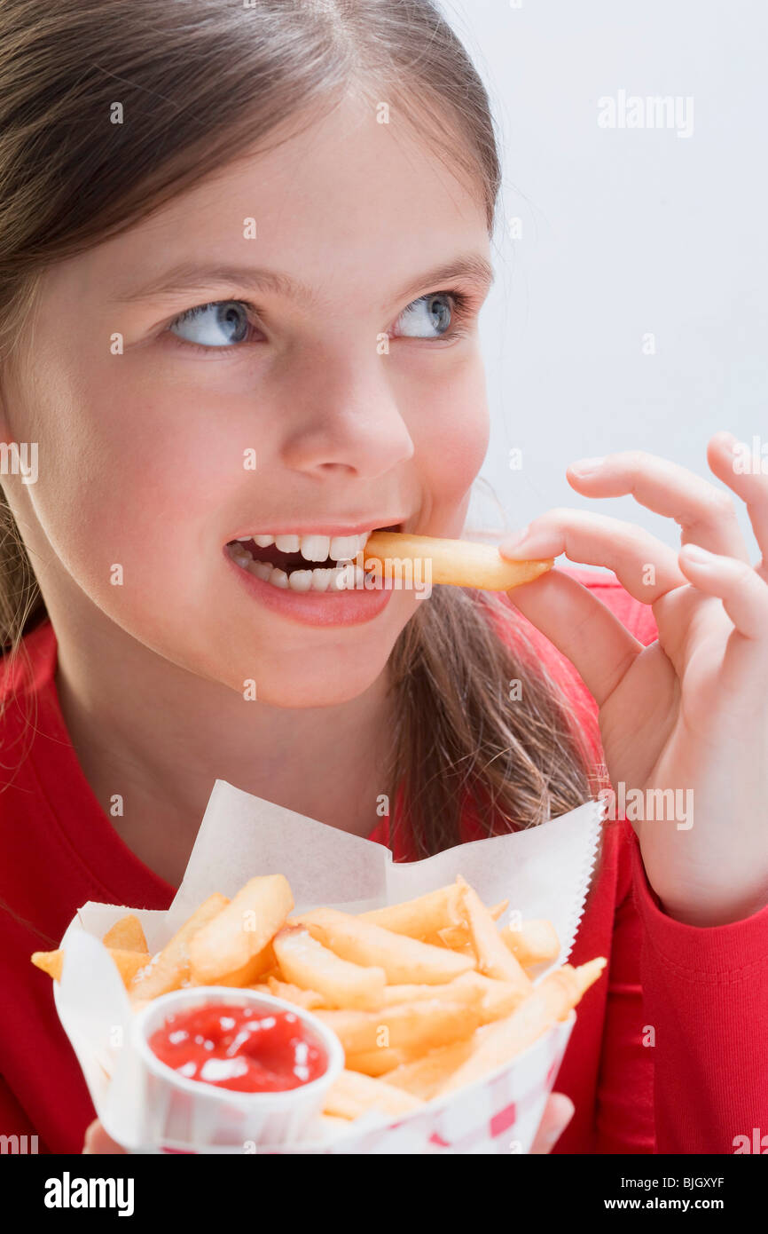 Girl holding a bag of chips and eating a chip Stock Photo Alamy