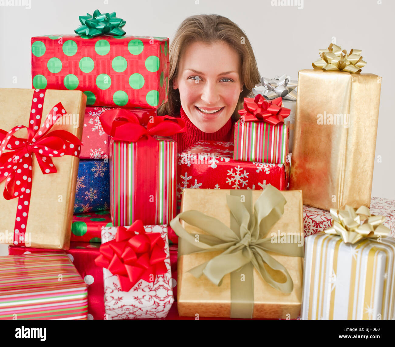 Woman behind Christmas presents Stock Photo Alamy
