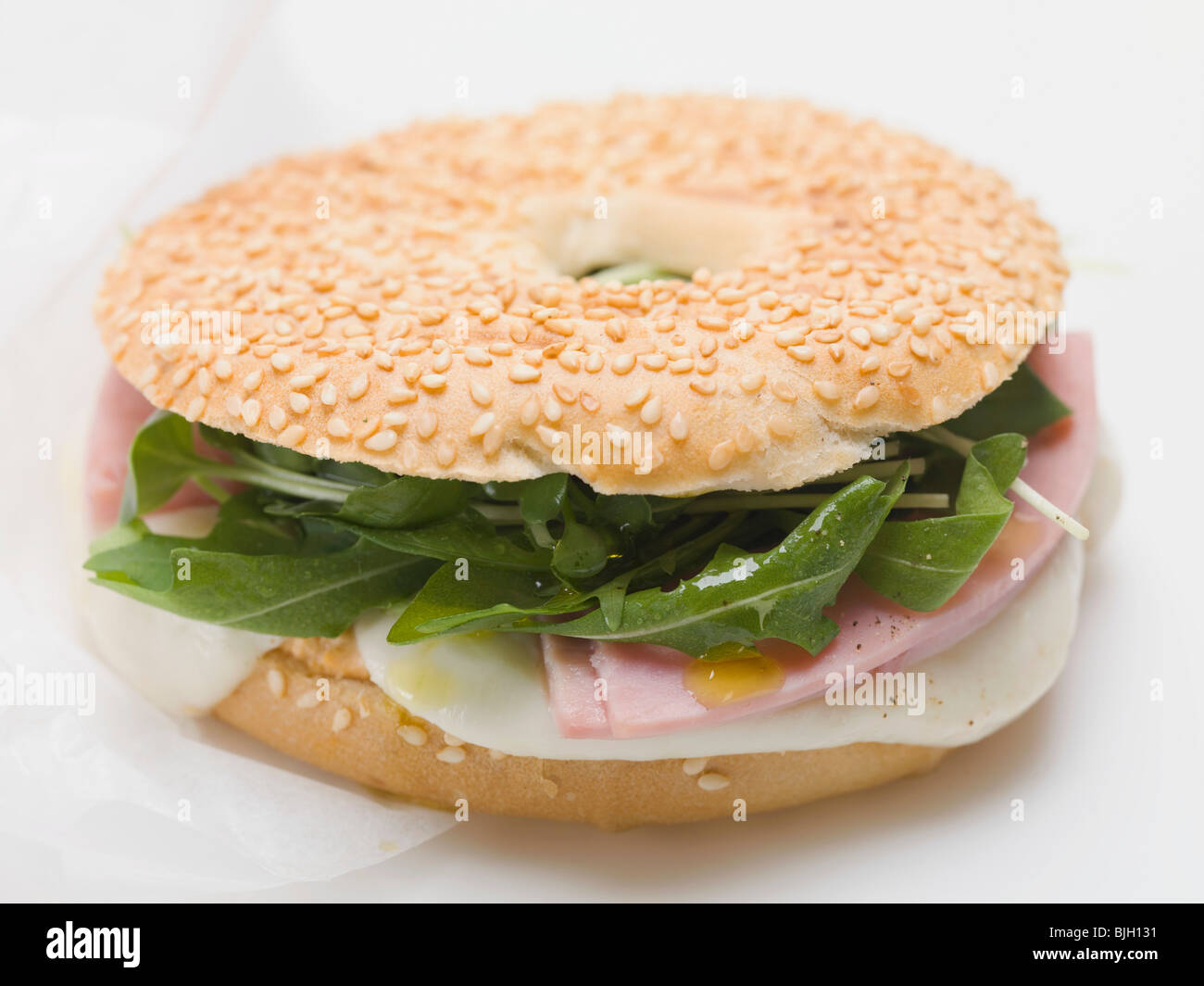 Ham, cheese and rocket in sesame bagel - Stock Photo