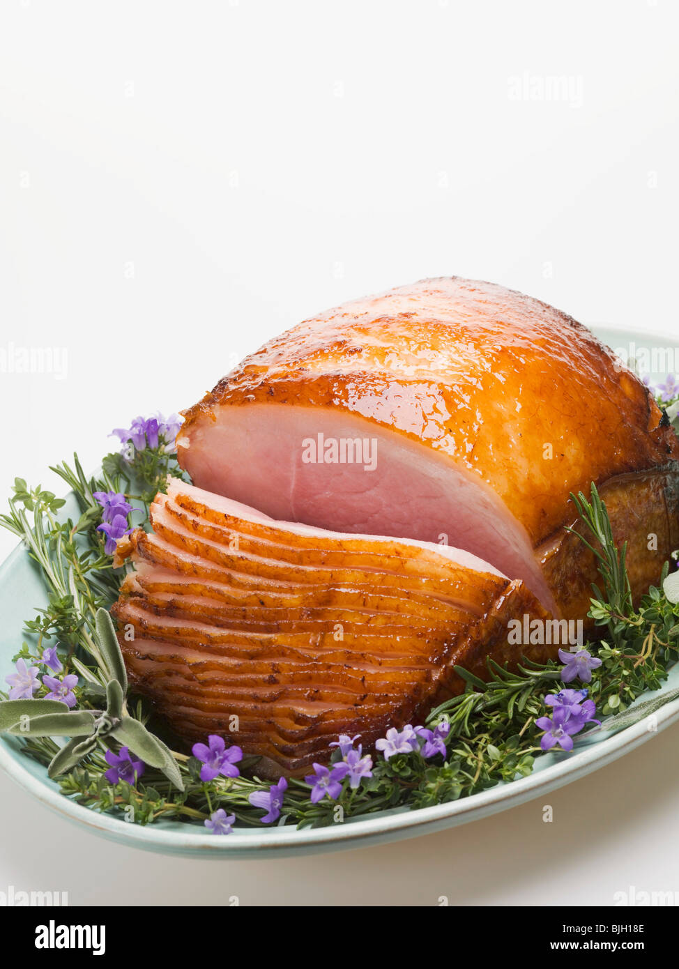 Glazed roast ham surrounded by herbs Stock Photo Alamy