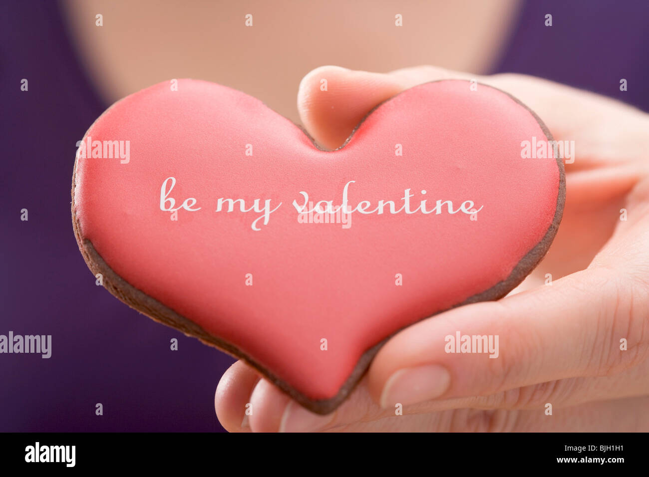 Hand holding a Valentine's Day biscuit - Stock Photo
