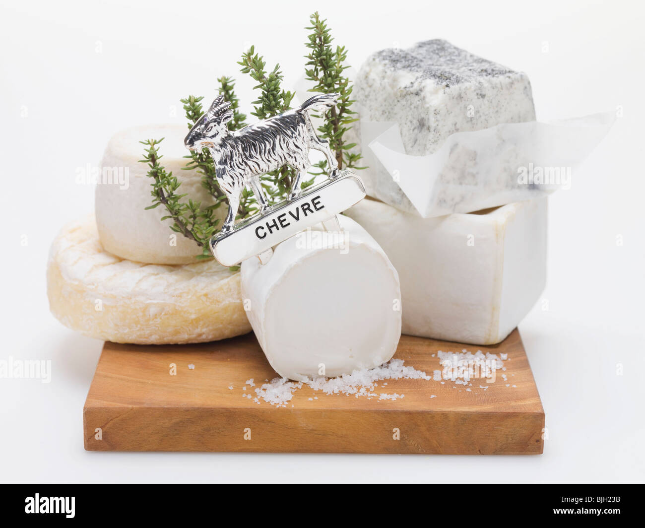 Various goat's cheeses on chopping board Stock Photo Alamy