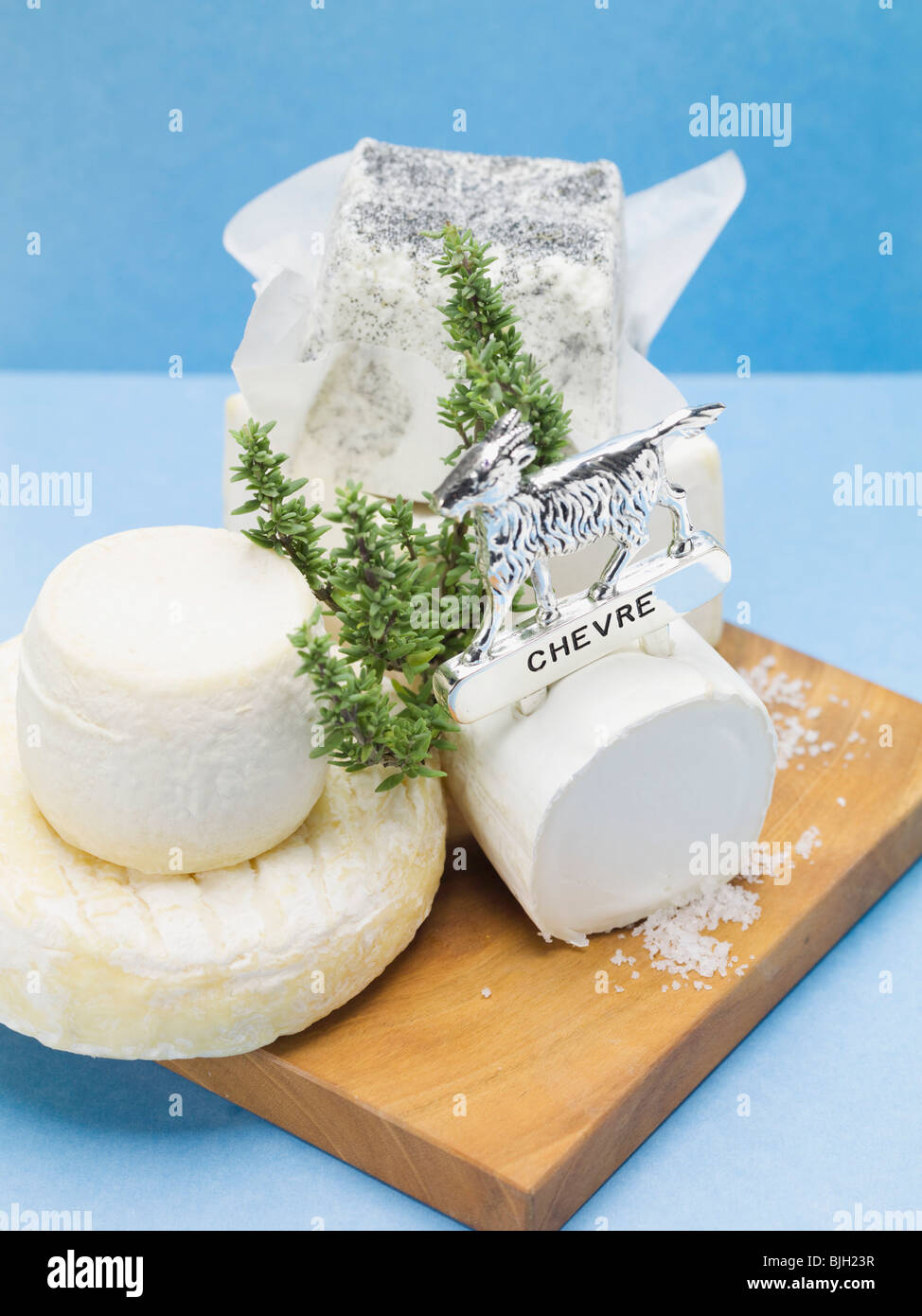 Various goat's cheeses on chopping board Stock Photo Alamy
