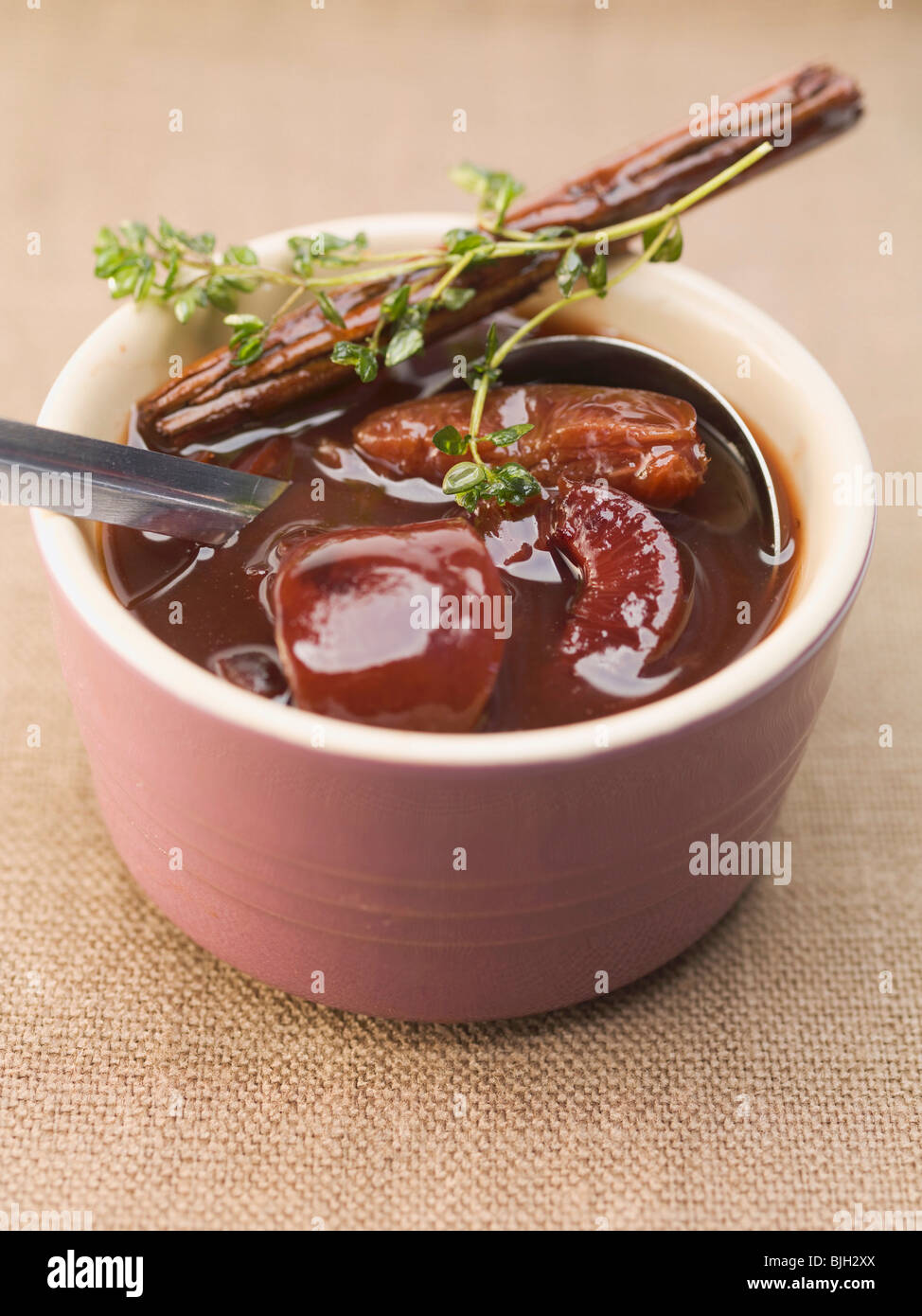Spiced plum sauce with cinnamon and thyme - Stock Photo