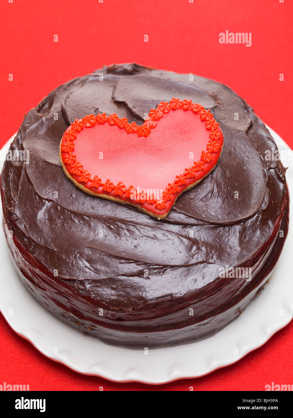 Chocolate cake with red heart-shaped biscuit Stock Photo - Alamy