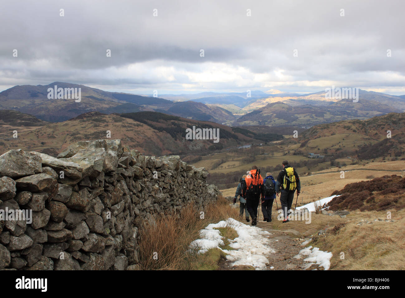 Four walkers descend from Cadair Idris via the Pony Path, Snowdonia National Park, Gwynedd, Wales, United Kingdom, UK, Europe Stock Photo