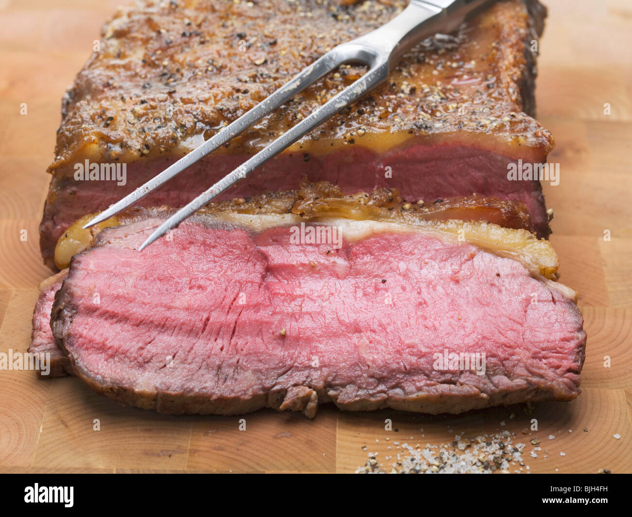 Roast beef with meat fork Stock Photo Alamy