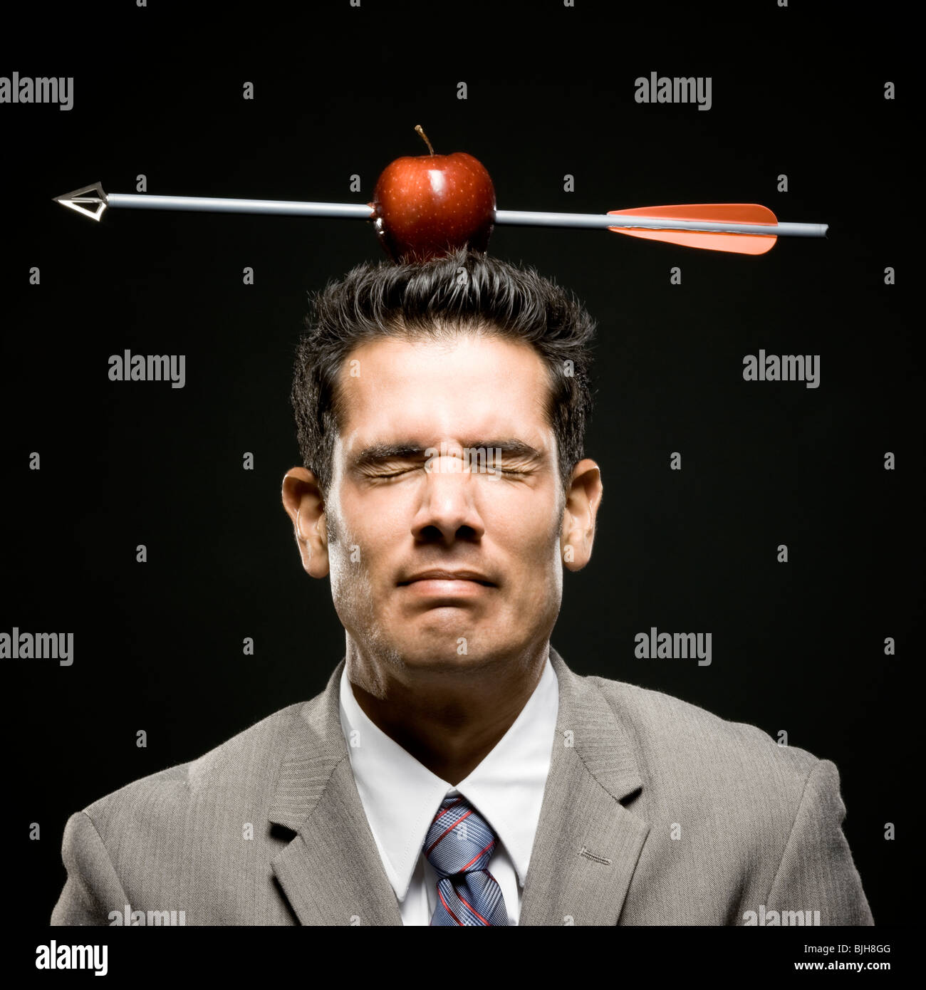 businessman with an apple on his head that has been shot with an arrow Stock Photo