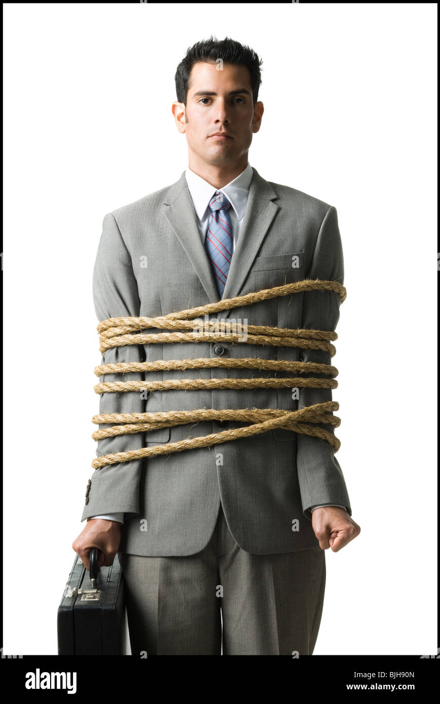 businessman in a full suit tied up with a rope around his mid